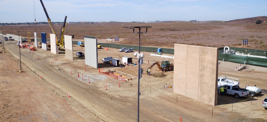 Construction crews prepare a set of border wall prototypes along the border near San Diego in October.