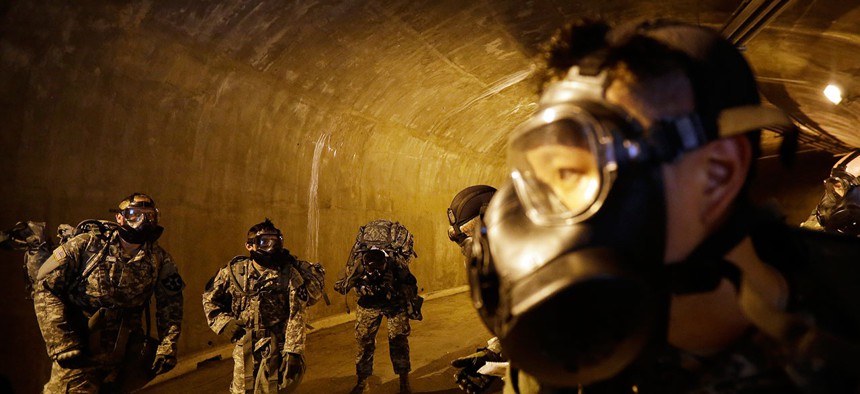 Soldiers of the U.S. Army 23rd chemical battalion wearing gas masks gather at a tunnel in 2015.