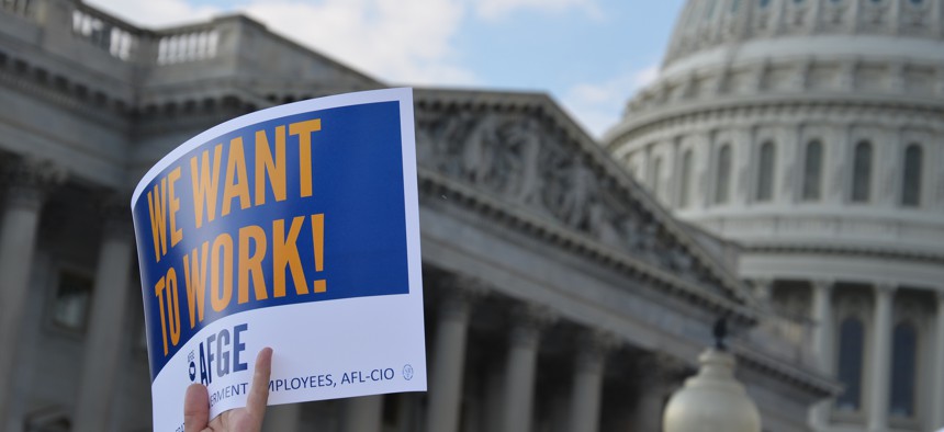 An AFGE member holds a sign during a rally in D.C. during the 2013 shutdown.