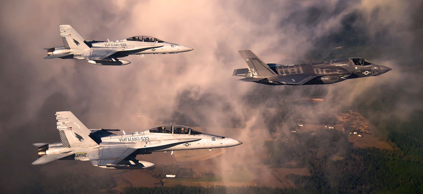 A Marine Corps F-35 Lightning II aircraft is escorted by two Marine F/A-18 Hornets.