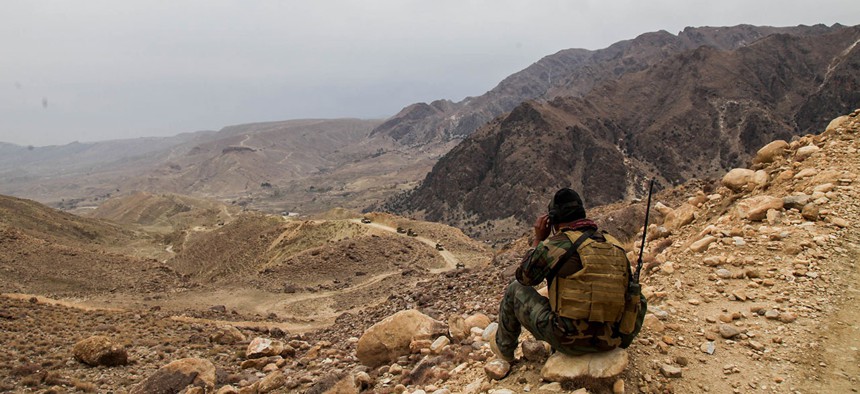 An Afghan 8th Special Operations Kandak Commando provides early warning for a convoy from a mountain top in Wach Kot Valley, Nangarhar province in December.