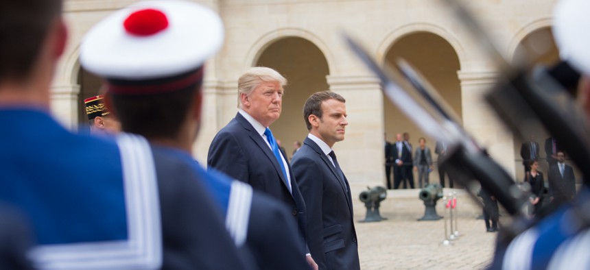 Donald Trump and Emmanuel Macron walk to a military parade in Paris in July.