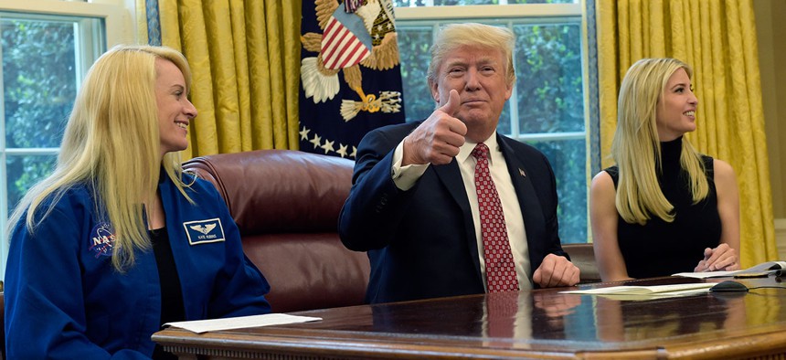 President Donald Trump, flanked by NASA astronaut Kate Rubins, left, and his daughter Ivanka Trump, gives a thumbs up following a video conference with the International Space Station