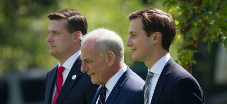 White House aides Rob Porter (left) and Jared Kushner (right) flank Chief of Staff Gen. John Kelly while heading to board Marine One, Friday, August 4, 2017.