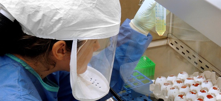 A CDC scientist harvests H7N9 virus that has been grown for the purpose of sharing with partner laboratories for research purposes in 2013.