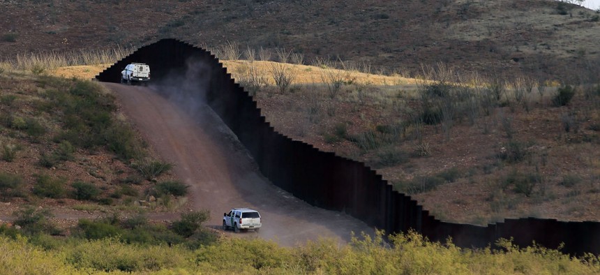 Border Patrol agents patrol near the fence in Naco, Ariz. 