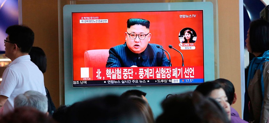 People watch a TV screen showing an image of North Korean leader Kim Jong Un during a news program at the Seoul Railway Station.
