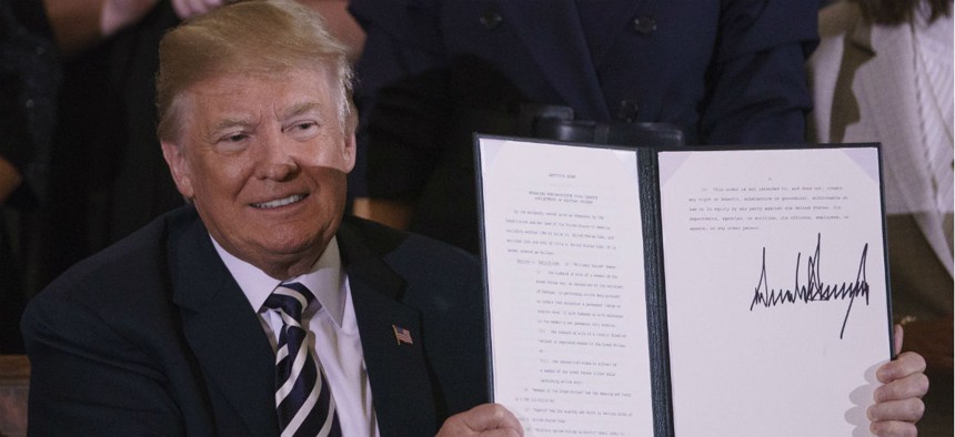 Trump holds up an executive order on military spouses. 