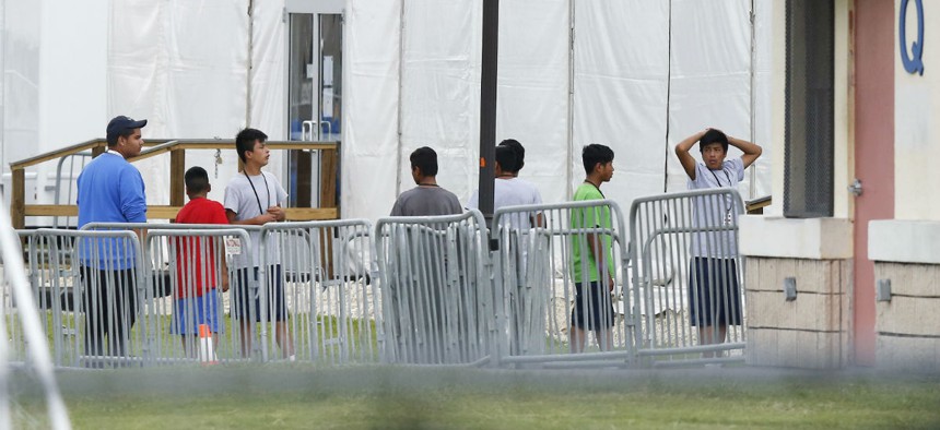 Immigrant children walk in a line outside the Homestead Temporary Shelter for Unaccompanied Children in Florida. 