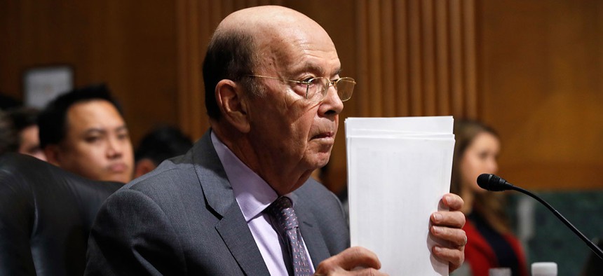 Secretary of Commerce Wilbur Ross straightens his papers during a Senate Finance Committee hearing on tariffs on Wednesday.