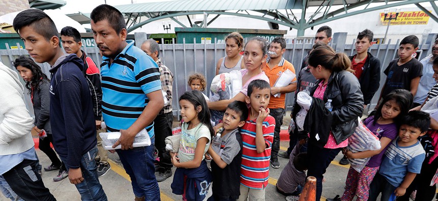 Immigrant families line up to enter the central bus station after they were processed and released by U.S. Customs and Border Protection on Sunday.