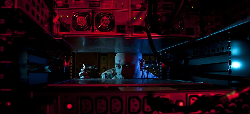 U.S. Air Force Staff Sgt. Jerome Duhan, a network administrator with the 97th Communications Squadron, inserts a hard drive into the network control center retina server at Altus Air Force Base.
