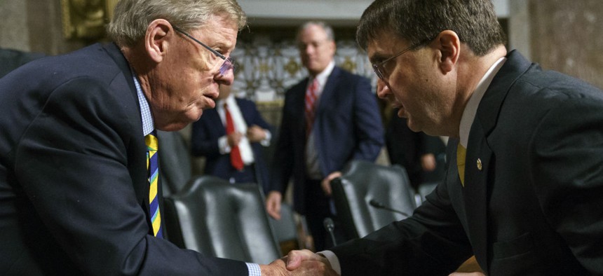 Robert Wilkie, right, shakes hands with Senate Veterans Affairs Committee chairman Johnny Isakson, R-Ga., left, after a nomination hearing in June.