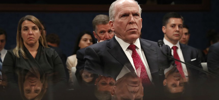 Former CIA Director John Brennan is reflected in a table as he prepares to testify on Capitol Hill before the House Intelligence Committee Russia Investigation Task Force in May 2017.