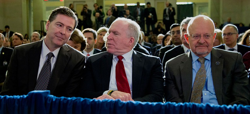 James Comey, John Brennan and James Clapper sit together at an NSA event in 2014.