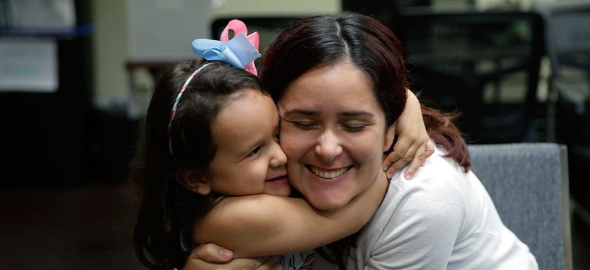 Immigrants seeking asylum Natalia Oliveira da Silva and her daughter, Sara, 5, hug as they wait at a Catholic Charities facility on July 23 in San Antonio.