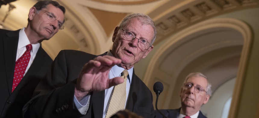 Sen. James Inhofe, R-Okla., a member of the Senate Armed Services Committee, center, joined by Sen. John Barrasso, R-Wyo., left, and Senate Majority Leader Mitch McConnell, R-Ky., talks about defense funding on Capitol Hill in Washington, June 12, 2018.