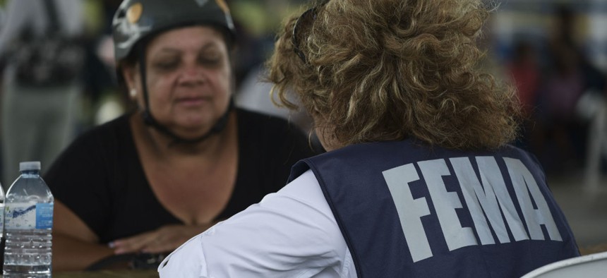 A resident meets with a FEMA representative to file forms for federal aid in the aftermath of Hurricane Maria in October 2017.