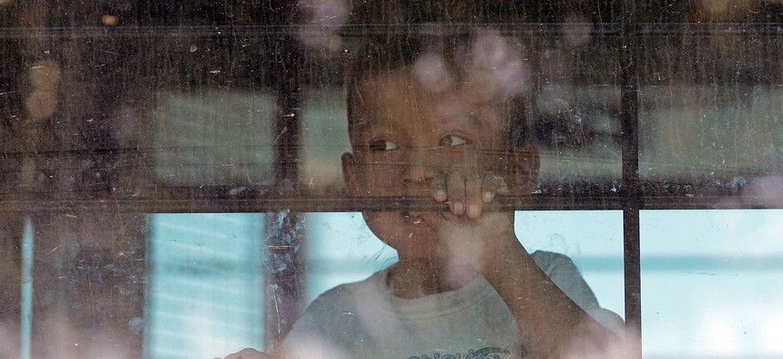 An immigrant child looks out from a U.S. Border Patrol bus in 2013.