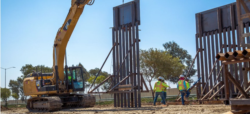 Construction workers put up a new wall panel in June at the Chula Vista Area of Responsibility, Calif.