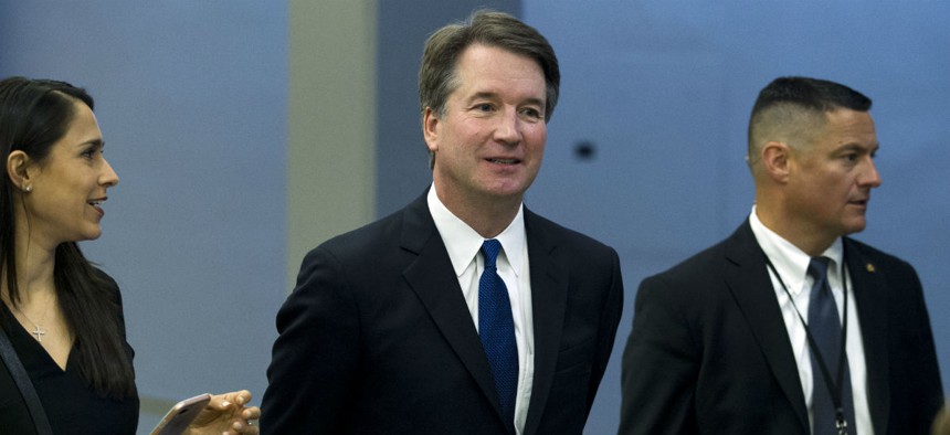 Supreme Court nominee Brett Kavanaugh (center) heads to a meeting on Capitol Hill. 