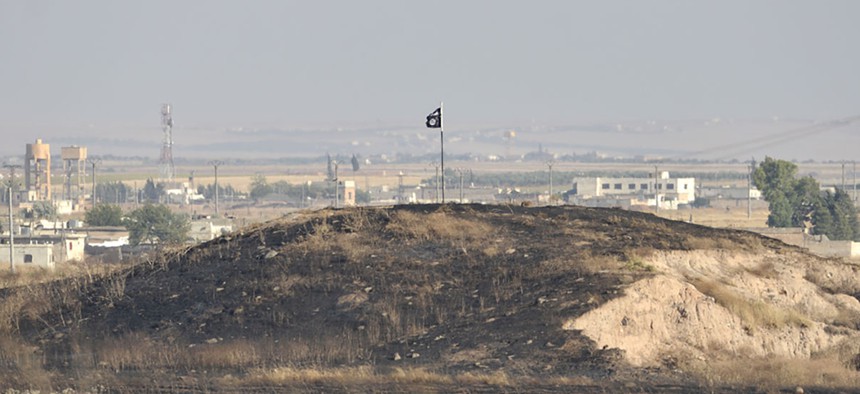An ISIS flag sits on a hill in Syria in 2015.