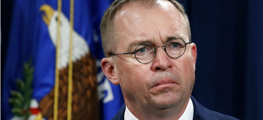 Acting CFPB Director Mick Mulvaney listens during a Justice Department news conference in July about fraud.