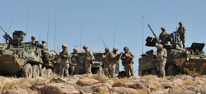 Soldiers from 4th Stryker Brigade Combat Team, 2nd Infantry Division and airmen from 5th Air Support Operations Squadron, along with observer-controllers, prepare for a Joint Air Attack Team exercise.