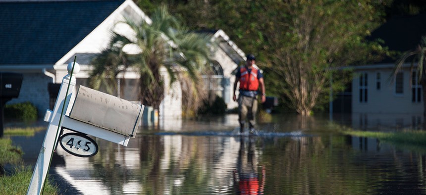 A Coast Guard member assigned to the Atlantic Strike Team walks through a flooded neighborhood in Longs, South Carolina, on Sept. 20.