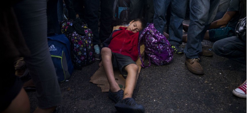A child in the “caravan” of largely Guatemalan, Honduran and El Salvadoran citizens sleeps on a bridge connecting Guatemala and Mexico. 
