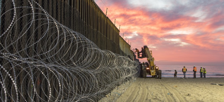 Border Patrol Agents at Border Field State Park in Imperial Beach watch over personnel that are reinforcing the border wall with concertina wire. 