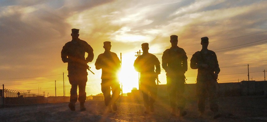 A group of U.S. Soldiers walks along the road at sunset in Taji, Iraq, in 2016.