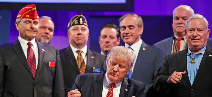 President Donald Trump prepares to sign the Veterans Appeals Improvement and Modernization Act in 2017.