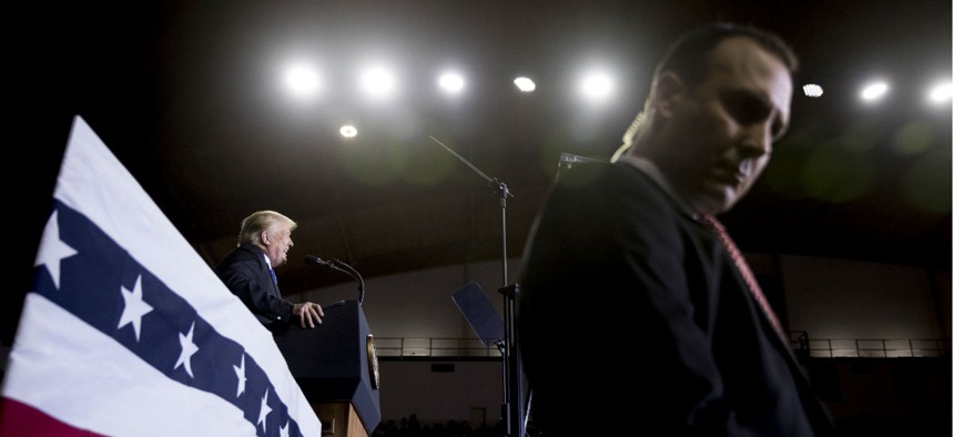 A Secret Service agent stands guard as Trump speaks at a rally in October. A measure on Trump's desk would boost pay caps for the Secret Service. 