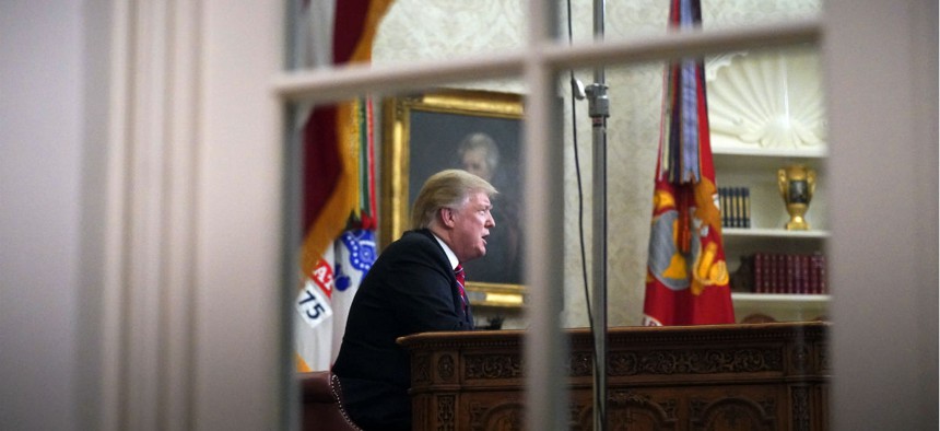 As seen from a window outside the Oval Office, President Donald Trump gives a prime-time address about border security on Tuesday evening.