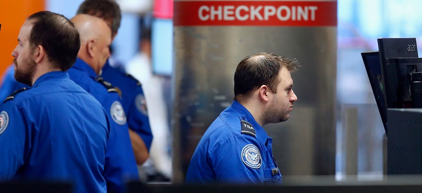 Transportation Security Administration officers work at a checkpoint at Logan International Airport in Boston on Saturday.