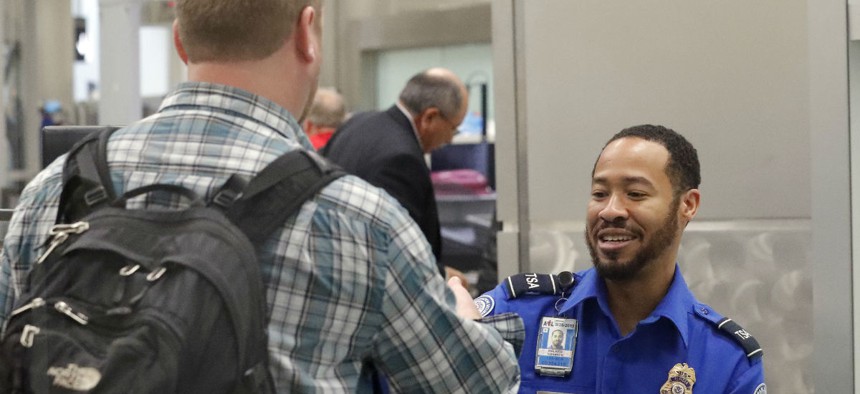 A TSA employee screens a passenger at Hartsfield-Jackson Atlanta International Airport in early January. The airport is one of several that have had to make adjustments due to unscheduled absences. 