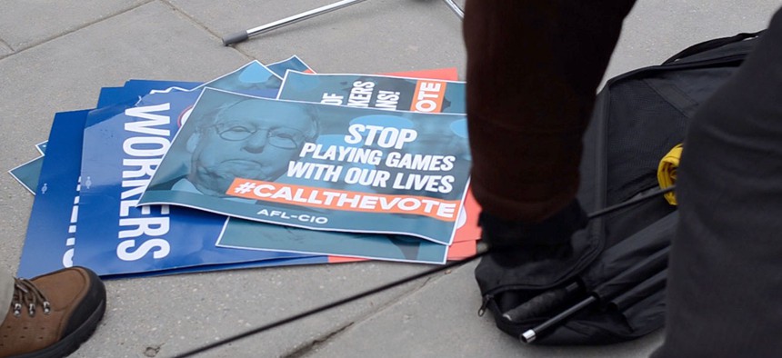 Signs from a rally protesting the shutdown sit on the ground on Thursday at Nationals Park in D.C.