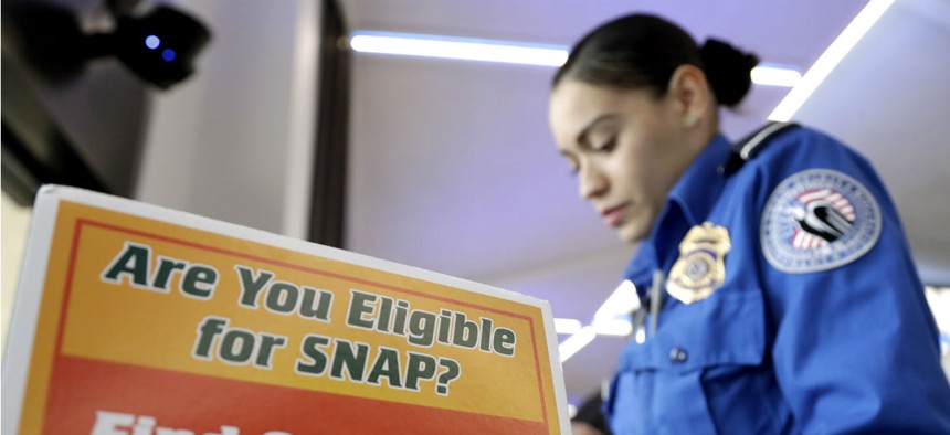 A TSA employee stands at a booth to learn about a food stamp program at a food drive at Newark Liberty International Airport on Jan. 23.