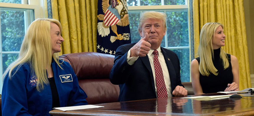 President Donald Trump, flanked by NASA astronaut Kate Rubins, left, and his daughter Ivanka Trump, gives a thumbs up following a video conference with the International Space Station on April 24, 2017.