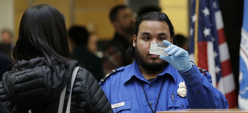 A TSA worker checks an identification card during the shutdown at Seattle-Tacoma International Airport. TSA staff were among the federal workers compelled to work without pay during the shutdown. 