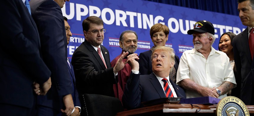 President Donald Trump hands a pen to Veterans Affairs Secretary Robert Wilkie during a spending bill signing ceremony in Las Vegas in September.