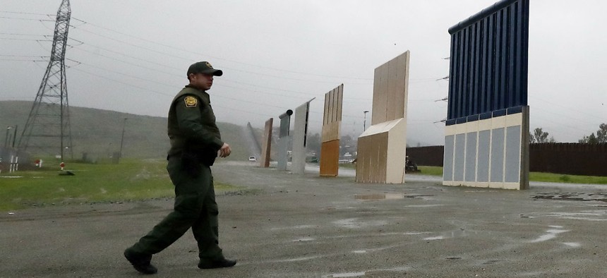 A Border Patrol agent approaches border wall prototypes in San Diego, Calif., earlier this month. 