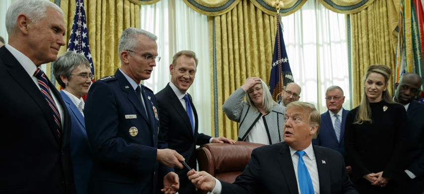 President Donald Trump hands a pen to Air Force Gen. Paul Selva after signing "Space Policy Directive 4" in the Oval Office on Tuesday.