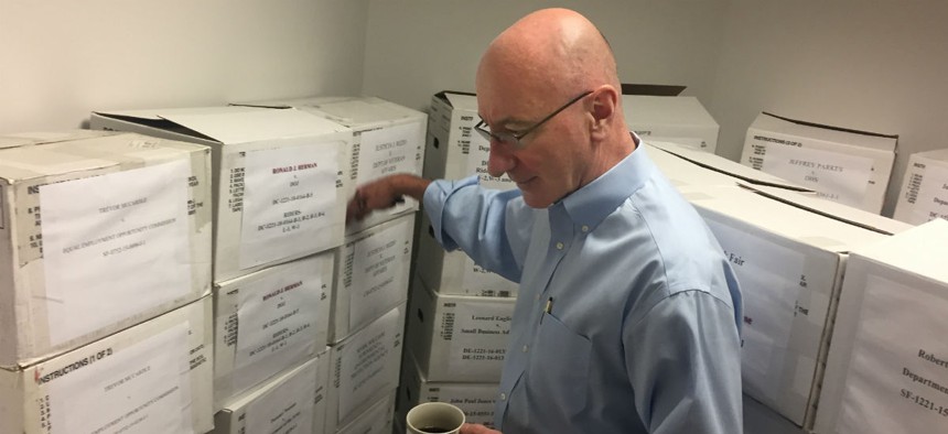 Mark Robbins, the last remaining member on MSPB's central panel, points out boxes full of cases. Thursday is Robbins's last day. 