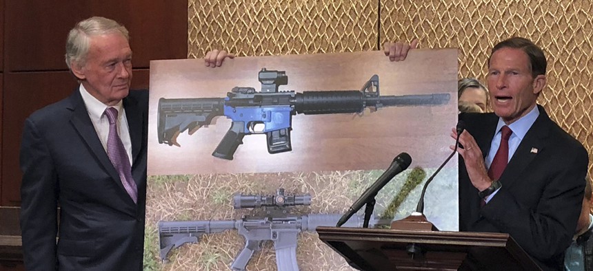 Sen. Edward Markey, D-Mass., left, and Sen. Richard Blumenthal, D-Ct., display a photo of a plastic gun on Capitol Hill in July.