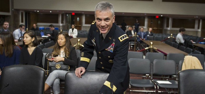 Army Lieutenant General Paul Nakasone arrives at the witness table to appear before the Senate Armed Services Committee to discuss his qualifications as nominee to be National Security Agency Director and U.S. Cyber Command Commander, during a hearing.