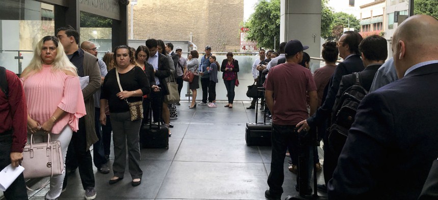 Immigrants awaiting deportation hearings line up outside federal court in Los Angeles. President Trump’s budget would fund more immigration judges to help handle the backlog of cases.