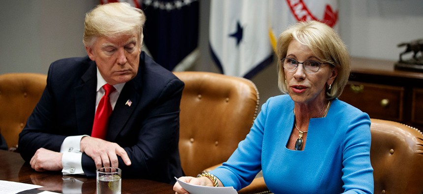 President Donald Trump listens as Secretary of Education Betsy DeVos speaks during a roundtable discussion on the Federal Commission on School Safety report, at the White House in December.
