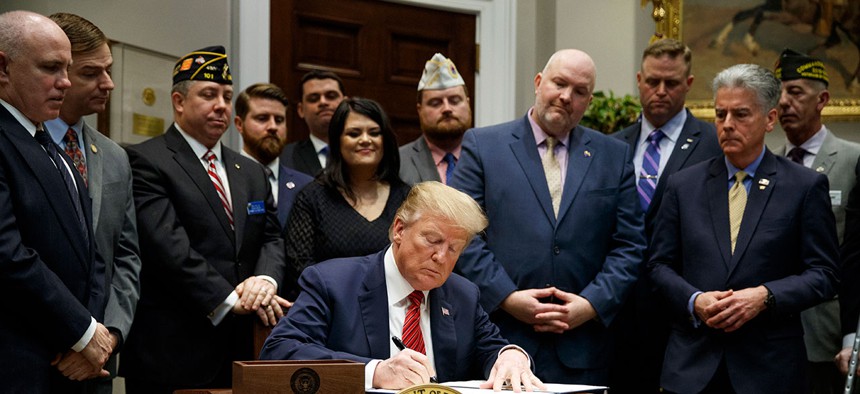 President Donald Trump signs an executive order on a "National Roadmap to Empower Veterans and End Veteran Suicide" at the White House on March 5.